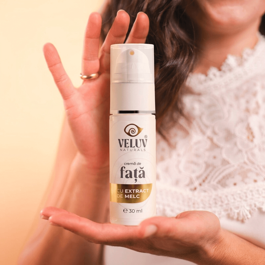 Femeie elegantă ținând flaconul de cremă de față cu extract de melc Veluv Naturals 30ml